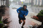 Мужчина бежит в защищенное место от ветра и дождя, вызванных ураганом «Иен» в Сарасоте, Флорида, 28 сентября 2022 года