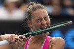 Теннисистка Марта Костюк с Украины кусает ракетку во время матча против Элины Аванесян из России на чемпионате Australian Open в Мельбурне, Австралия, 19 января 2024 года
