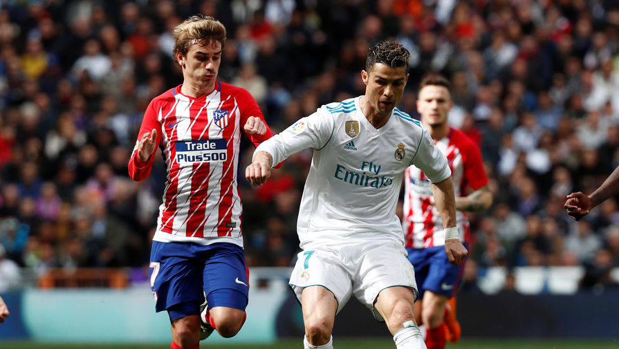 Нападающий «Реала» Криштиану Роналду борется за мяч с форвардом «Атлетико» Антуаном Гризманном