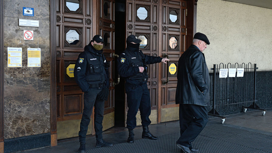 Сотрудники полиции у дверей центрального железнодорожного вокзала в Киеве, 18 марта 2020 год
