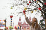 Девушка рассматривает новогодние украшения на Манежной площади в Москве
