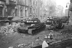 <b>ИС-2</b>
<br><br>
Тяжелый танк «Иосиф Сталин» был разработан для прорыва укрепленных позиций противника. Оснащен мощной 122-мм пушкой, которая могла пробивать броню большинства немецких танков, имел хорошую защиту. А лобовая броня самого ИС-2 была толще на 20 мм, чем у первого «Тигра» с его 100 мм.
<br><br>
ИС-2 был самым эффективным советским тяжелым танком на завершающем этапе войны, он мог на равных биться с немецкими «тяжеловесами». Всего их выпустили более 3300 единиц.
<br><br>
На фото: колонна советских тяжелых танков ИС-2 на одной из улиц Берлина, 30 апреля 1945 года