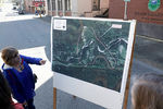 Местная жительница смотрит на карту с указанием местности, где оползень накрыл дома и часть шоссе
