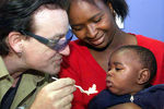 Боно кормит ребенка в женской ВИЧ-клинике в южноафриканском городе Соуэто, 2002 год
