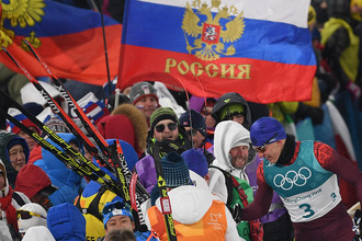 Российский спортсмен Александр Большунов с болельщиками после финиша спринта среди мужчин в финальных соревнованиях по лыжным гонкам на Олимпиаде в Пхенчхане, 13 февраля 2018 года