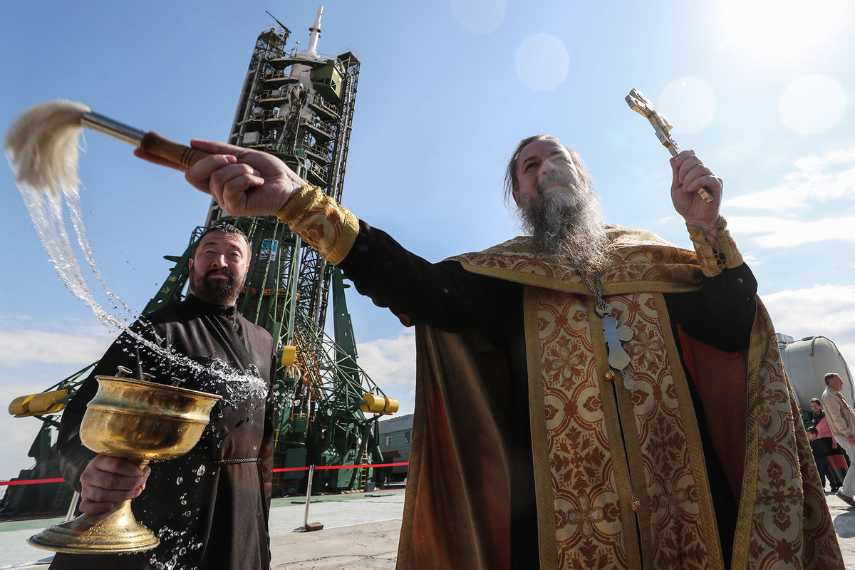 Освятить святой водой. Батюшка освящает ракету. Освящение. Священник освящает. Батюшка освещает.