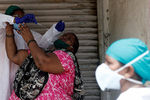Врач пытается взять мазок на коронавирус у жительницы Мумбая, сентябрь 2020 года