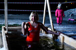 Екатеринбург. Женщина окунается в купель во время празднования Крещения на озере Шарташ, 18 января 2023 года