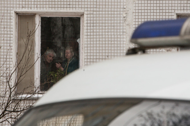 Жители дома напротив наблюдают за ситуацией у школы №263