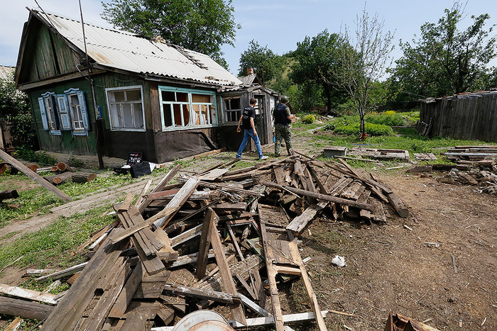 Сотрудники Следственного комитета во время работы у жилого дома в российском Донецке, во дворе которого разорвался снаряд украинской армии