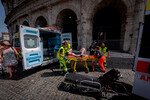 Врачи оказывают помощь туристу у Колизея, которому стало плохо из-за жаркой погоды, Рим, Италия