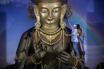 Рабочий готовит статую Будды к празднованию Лунного Нового года в храме «Сатья Будда» в Медане, 12 января 2023 года