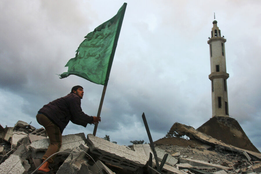 Палестинец с флагом ХАМАСа на развалинах разрушенной мечети после авиаудара Израиля по городу Газа, 31 декабря 2008 года