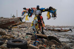 Экологический активист Моду Фаль («Пластиковый человек») на заваленном мусором пляже Ярах в Дакаре, Сенегал, 8 ноября 2022 года
