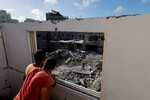 Палестинцы в своем доме, поврежденном в результате израильского удара, смотрят на руины в Хан-Юнисе на юге сектора Газа, 7 ноября 2023 года