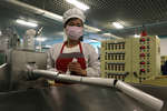 Сотрудница фабрики по производству зубной пасты в защитной маске, Пхеньян, 16 мая 2022 года