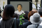 Люди собираются, чтобы возложить цветы к храму Дзодзёдзи, где прошли похороны покойного бывшего премьер-министра Японии Синдзо Абэ, застреленного во время кампании по парламентским выборам, в Токио, Япония, 12 июля 2022 год