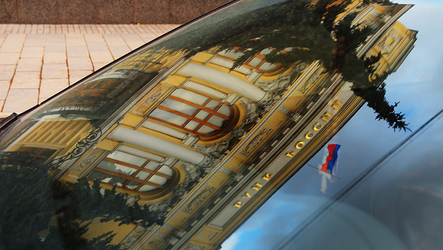Здание Центрального банка России на Неглинной улице в Москве в отражении на лобовом стекле автомобиля