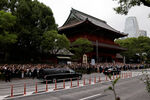 Автоколонна с телом покойного бывшего премьер-министра Японии Синдзо Абэ, застреленного во время кампании по проведению парламентских выборов, уезжает после его похорон в храме Дзодзёдзи в Токио, Япония, 12 июля 2022 год