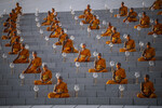 Буддийские монахи готовятся к ритуалу зажигания фонарей в День Весака в храме Ват Пхра Дхаммакайя на окраине Бангкока, 3 июня 2023 года