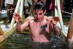 Новосибирск. Молодой человек окунается в купель во время празднования Крещения на реке Обь, 19 января 2023 года