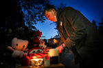 Студент зажигает свечу на мемориале в память о погибших во время стрельбы в Пермском государственном национальном исследовательском университете перед входом в университет, Пермь, 21 сентября 2021 года