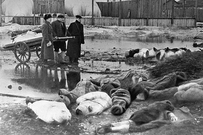 Трое мужчин хоронят умерших в дни блокады в Ленинграде
