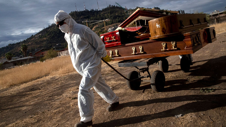 Сотрудник кладбища в Сантьяго, Чили, выполняет свою работу во время пандемии коронавируса, 21 апреля 2021 года