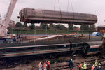 Пожарные и работники железной дороги поднимают вагон поезда, потерпевшего крушение около станции Паддингтон, 9 октября 1999 года
