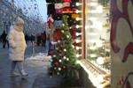 Девушка у праздничной новогодней витрины магазина в центре Москвы