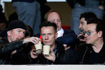 Члены ирландской рок-группы U2 распивают напитки во время футбольного матча, 2015 год