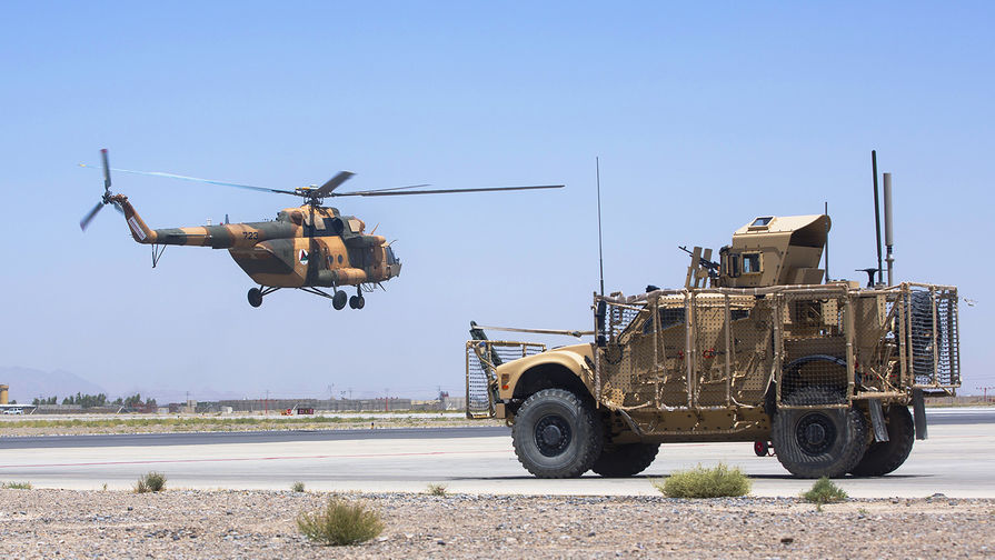 Вертолет национальной армии Афганистана и бронемашина ВС США на авиабазе в Кандагаре