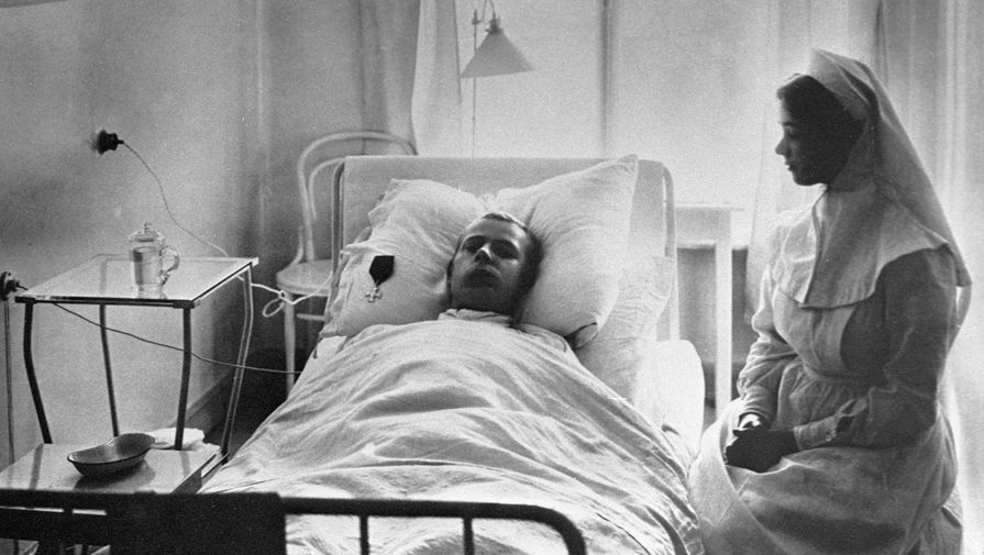 Медицинская сестра у постели раненного во время русско-японской войны солдата в эвакуационном лазарете императрицы Марии Федоровны