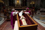 Архиепископ Георг Генсвайн закрывает лицо бывшего папы Бенедикта XVI, лежащего в гробу в базилике Святого Петра перед его похоронами в Ватикане, 4 января 2023 года
