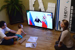 Молодая семья во Владивостоке смотрит телевизионную трансляцию послания президента РФ Владимира Путина к Федеральному Собранию