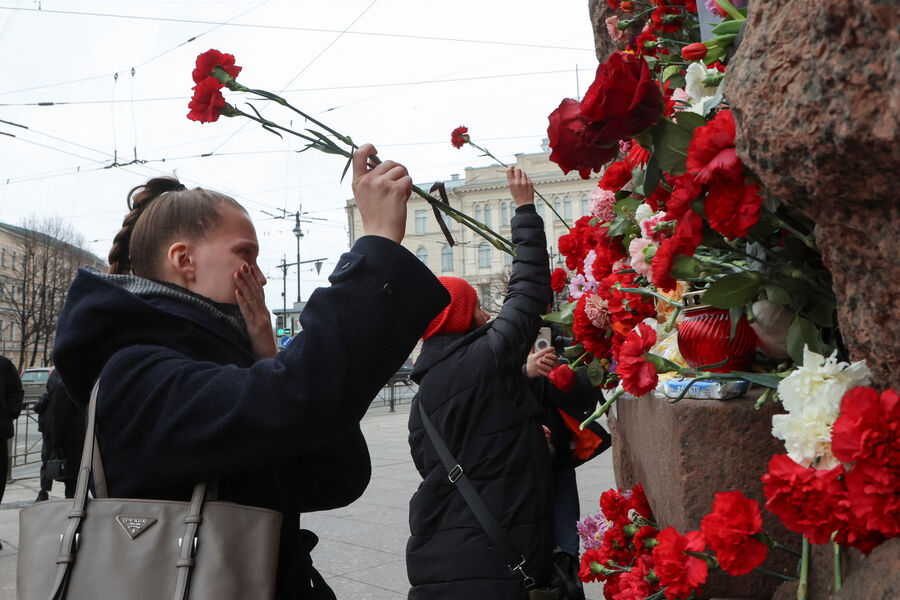 Люди возлагают цветы к&nbsp;стихийному мемориалу в&nbsp;память о&nbsp;жертвах теракта в&nbsp;подмосковном &laquo;Крокус Сити Холле&raquo; в&nbsp;Санкт-Петербурге, 23&nbsp;марта 2024&nbsp;года