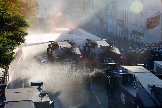 Водометы полиции и протестующие во время демонстрации накануне саммита G20 в Гамбурге, 6 июля 2017 года