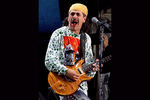 Гитарист Карлос Сантана со своей группой Santana во время фестиваля «Вудсток» в штате Нью-Йорк, 1994 год. Сантана выступал на одноименном фестивале в 1969 году