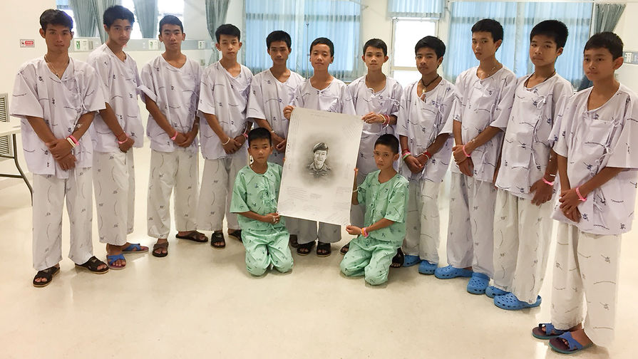 Дети, спасенные из пещеры в Таиланде, на выписке из больнице держат портрет погибшего бывшего военного офицера-подводника Самарна Кунана