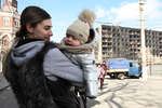 Девушка с ребенком на одной из улиц в Мариуполе, апрель 2022 года