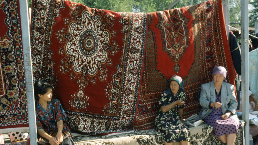 Торговля туркменскими коврами на вещевом рынке в городе Жымбыл в Казахстане, 1993 год