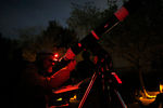 Любитель астрономии из Сан-Франциско вглядывается в свой телескоп в ожидании полного лунного затмения в Шабо