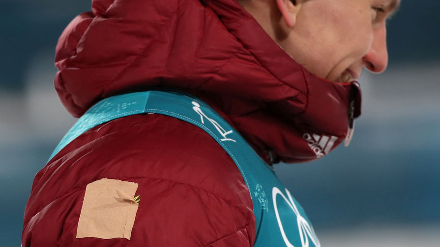 Российский спортсмен Александр Большунов с заклеенным гербом России после финиша дистанции спринта среди мужчин в полуфинальных соревнованиях по лыжным гонкам на Олимпиаде в Пхенчхане, 13 февраля 2018 года