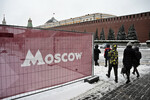 Люди гуляют по Красной площади во время ледяного дождя в Москве, 22 ноября 2022 года