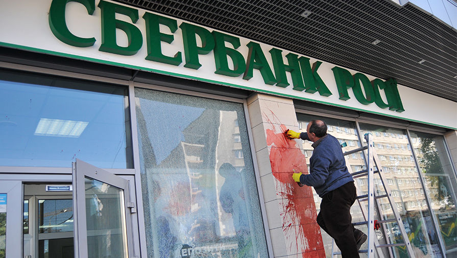 Сотрудник Сбербанка очищает фасад здания от краски, которой его облили неизвестные, 2014 год 