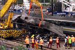 Пожарные и работники железной дороги поднимают вагон поезда, потерпевшего крушение около станции Паддингтон, 8 октября 1999 года