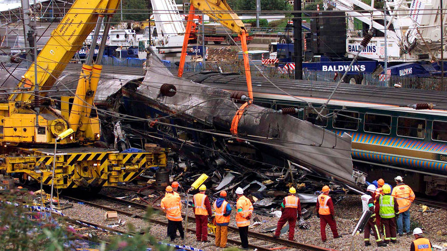 Пожарные и работники железной дороги поднимают вагон поезда, потерпевшего крушение около&nbsp;станции Паддингтон, 8 октября 1999 года