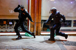 Полицейский догоняет демонстранта во время акции протеста возле штаб-квартиры Социалистической партии Испании (PSOE), Мадрид, 9 ноября 2023 года