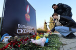 Люди возлагают цветы к стихийному мемориалу в память о жертвах теракта в подмосковном «Крокус Сити Холле» в Евпатории, 23 марта 2024 года