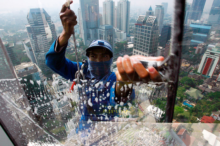 Промышленный альпинист моет окна в&nbsp;одном из&nbsp;зданий в&nbsp;Бангкоке